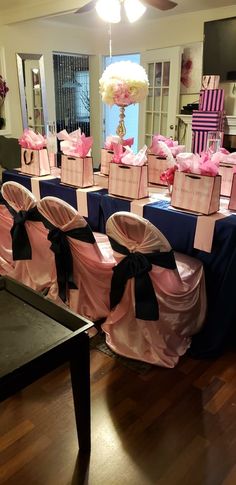 a room filled with lots of chairs covered in pink and blue cloths on top of a hard wood floor