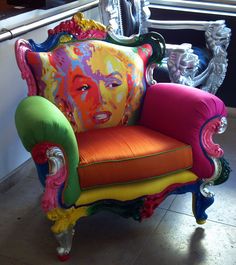 a colorful chair with an image of a woman painted on it's back and sides