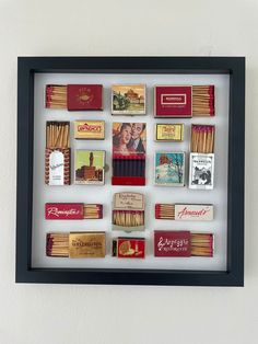 a shadow box filled with matches and matchsticks in it's black frame