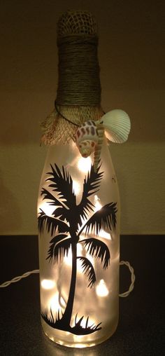 a bottle that has some lights in it with a palm tree on the inside and light up