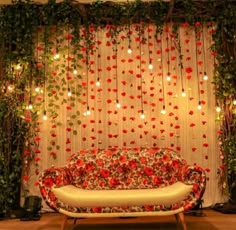 a couch sitting in front of a curtain covered with flowers