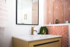 a bathroom sink sitting under a mirror next to a wall mounted faucet in front of a mirror