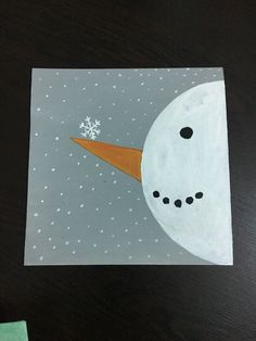 a drawing of a snowman's nose on top of a paper with the moon in the background