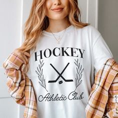 Gear up your inventory with our Hockey Athletic Club Comfort Color Tee, a must-have for fans of the game looking to showcase their passion in style. Crafted with premium materials and featuring a dynamic design, this tee is the perfect addition to any sports enthusiast's wardrobe. For those who bleed hockey, this tee is a statement piece, boasting bold graphics and vibrant colors that capture the essence of the game. Whether you're cheering from the stands or hitting the ice yourself, this tee i White Athleisure Tops For Game Day, Sporty Team Logo Top For Sports Season, Sporty Fan Merchandise Tops With Team Logo, Sporty Tops With Team Logo For Sports Events, Sporty Top With Team Logo For Sports Season, White Sporty T-shirt For Fan Merchandise, Athleisure Graphic Print T-shirt For Game Day, Sporty Tops For Sports Season Fan Merchandise, White Sublimation Design Fan Apparel For Sports Season