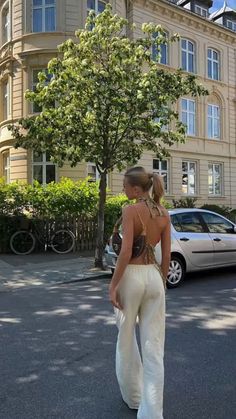 a woman in white pants walking down the street