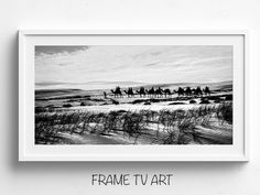 a black and white photo of people riding horses in the desert with text frame tv art