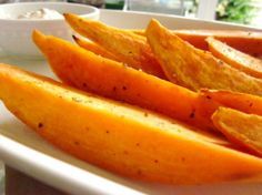 a white plate topped with sliced up oranges and potato wedges on top of it