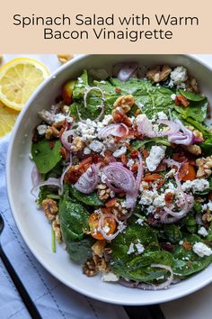 spinach salad with warm bacon vinaigrette and feta cheese on top