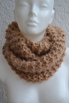 a white mannequin head wearing a brown knitted cowl