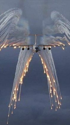 an airplane is flying in the sky with lights on it's wings as it flies through the air