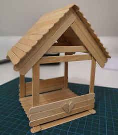 a wooden model of a house with a roof made out of plywood and wood