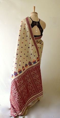 This is hundred percent authentic Muga Silk Saree . It has Muga silk in the warp and weft .   The interwoven motif yarns are in cotton and acrylic . Border attached which is the usual manner of border weaving in the region.  The design is traditional and known as Gamkharu and one of the most iconic designs of the region. The red and Muga combination is the classic combination that was always part of the bridal trousseau.  Muga Silk - The most valued silk from India. Almost exclusively reared and Luxury Katan Silk Traditional Wear Handloom, White Bohemian Handloom Traditional Wear, Traditional Handloom Wear For Festival, White Dupatta With Woven Motifs For Transitional Season, Bohemian Embroidered Cotton Fabric In Traditional Drape, Bohemian White Saree With Woven Motifs, Transitional White Dupatta With Woven Motifs, Bohemian Tussar Silk Dupatta With Zari Weaving, Bohemian Handloom Traditional Wear