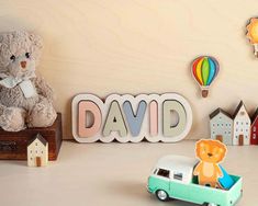 a teddy bear sitting on top of a table next to a sign that says david