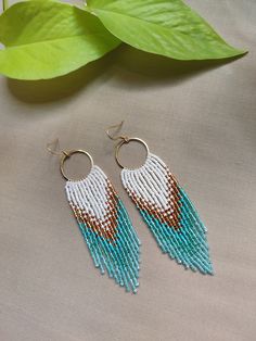 Step into the realm of timeless elegance with our "Athena's Whisper Fringe Earrings". Handcrafted with love & precision, these earrings feature a palette of shimmering Miyuki beads in a harmonious blend of crystal white, sun-kissed gold & serene shades of sky blue. Their intricate brick stitch design, reminiscent of ancient Greek mosaics, adds a touch of elegance & sophistication. As these earrings dance gracefully with every movement, they radiate an aura of ethereal beauty that will captivate Latkan Round Bead Earrings For Weddings, Bohemian Beaded Drop Bridal Earrings, Bohemian Beaded Bridal Earrings, Bohemian Beaded Bridal Drop Earrings, Bohemian Beaded Danglers For Celebration, Colorful Dangle Beads Jewelry For Celebration, Bohemian Round Beads Earrings For Wedding, Bohemian Round Bead Wedding Earrings, Adjustable Bohemian Earrings For Celebrations