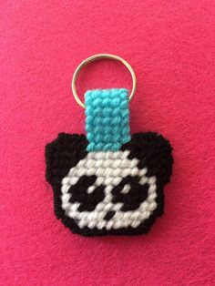 a crocheted keychain with a black and white cat face on it