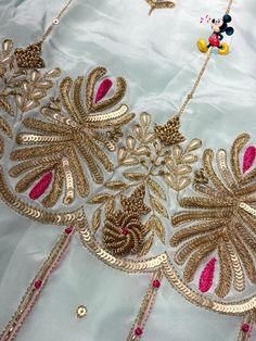 an elaborately designed dress with gold and pink beads on the neck, along with other accessories