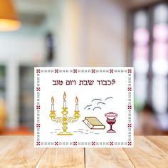 a table with a card on it that says happy hanukkah in hebrew