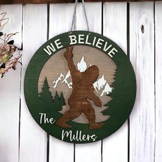 a wooden sign hanging on the side of a white fence that says, we believe the millers