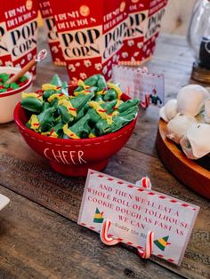 candy in a bowl on a table with other candies and signs around it for sale