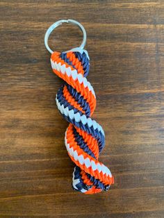 an orange, white and blue rope keychain sitting on top of a wooden table