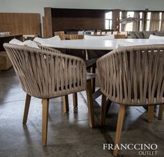 two wicker chairs sitting next to each other at a table