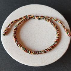 a white plate topped with a colorful bracelet