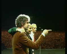 two men standing next to each other in front of a crowd