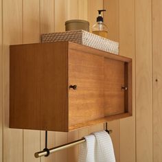 a wooden shelf with towels hanging from it's sides and a towel rack attached to the wall