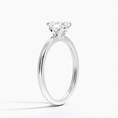 a white gold engagement ring with a single diamond in the center, on a white background