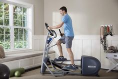 a man is using an exercise bike in the living room