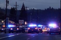 several police cars are parked on the side of the road at night with their lights on