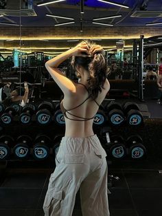 a woman standing in front of a gym machine