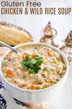 a white bowl filled with chicken and wild rice soup on top of a blue and white napkin