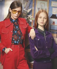 two women standing next to each other in red and purple outfits