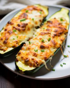 an eggplant stuffed with cheese and green onions on a white plate next to a fork