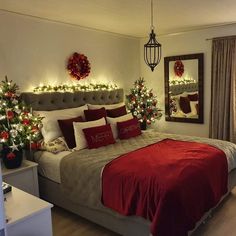 a bedroom decorated for christmas with lights on the headboard and red bed linens