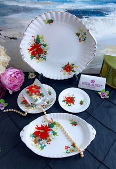 an assortment of porcelain dishes and decorations on display in front of a painting with flowers