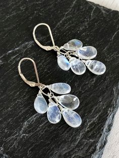 Rainbow Moonstone Earrings, White Cluster Earrings in Gold or Silver, Teardrop Statement Earrings, June Birthstone Jewelry Gift for women These luminous white cluster earrings feature blue flash rainbow moonstone teardrops wire wrapped to an oval chain forming a short cluster. These white statement earrings are perfect for summer and matching with virtually everything in your closet, they have lots of blue flash so they reflect colors from within. These will turn heads anywhere you go. About The White Statement Earrings, Watermelon Tourmaline Necklace, Tiny Heart Necklace, June Birthstone Jewelry, Rose Quartz Heart, Tourmaline Necklace, Moonstone Earrings, Earrings In Gold, June Birthstone