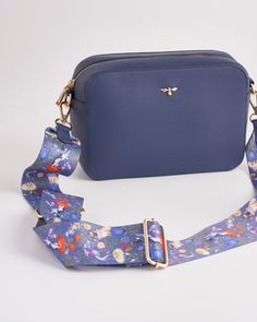 Expertly crafted in our oh-so chic, Navy Blue shade, our ever-popular camera bag is the ideal contemporary, everyday carryall. Wear over the shoulder or as cross the body bag and keep your hands free for exploring nature’s new-season delights. The detachable, printed strap illustrates our Pets Portraits print by British artist Catherine Rowe. Luxury, gold-tone hardware feature’s throughout whilst Fable’s signature bee completes this unique design.
  Key features:
  Approx. 22 (L) x 8 (W) x 15 (H Travel Camera Bag With Adjustable Crossbody Strap, Travel Camera Bag With Adjustable Strap And Crossbody Shape, Travel Crossbody Bag With Strap, Navy Travel Bag With Adjustable Strap, Blue Bag With Long Strap For Daily Use, Blue Travel Bag With Long Strap, Travel Crossbody Bag Strap, Navy Rectangular Bag With Detachable Strap, Blue Detachable Strap Bag Strap For Everyday