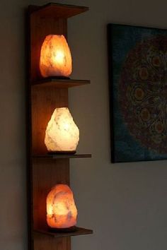 three lit candles sitting on top of wooden shelves