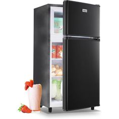 a black refrigerator with its door open next to a strawberries and milkshake