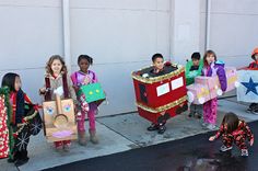 children in costumes are standing on the sidewalk