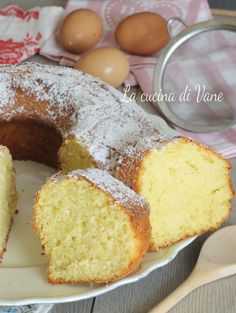 a bundt cake on a plate with one slice cut out and two eggs in the background