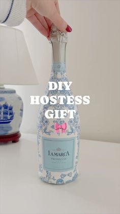 a person holding a bottle with the words diy hostess gift on it