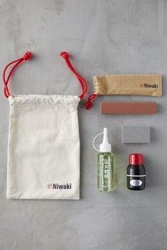 the contents of a travel kit are laid out on a gray surface, including an empty bag