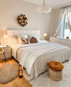 a bedroom with white walls and wooden floors