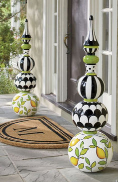 three black and white vases sitting on top of each other near a door way