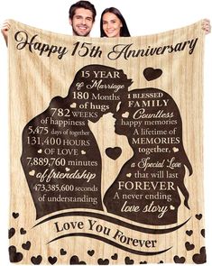 two people holding up a wooden anniversary blanket