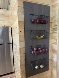 a metal rack with fruit and vegetables on it next to a refrigerator in a cabin