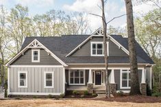 a gray and white house in the woods